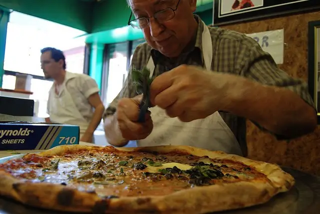 Di Fara owner Dom DeMarco puts the finishing touch on his pie